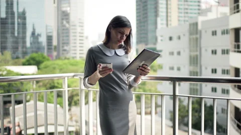 Businesswoman comparing data on tablet computer and smartphone on terrace HD Stock Footage 51439804