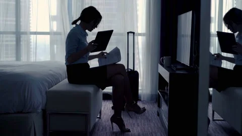 Businesswoman comparing data on tablet computer and documents on bed at hotel 4K Stock Footage 89154635