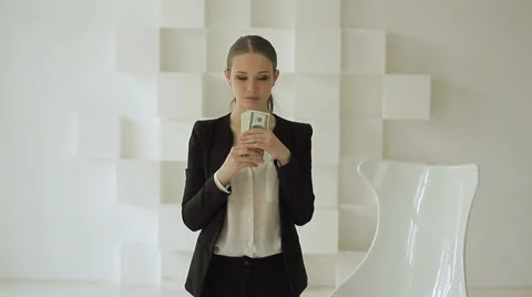 Businesswoman is counting money, fanning herself with dollars, and giving them. Stock Footage