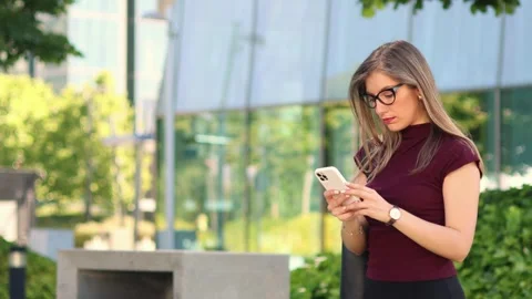 Businesswoman experiencing stress while using smartphone in financial distric Stock Footage 317014374