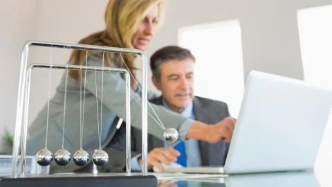 Businesswoman explaining something on the computer to a concentrated businessman Stock Photos