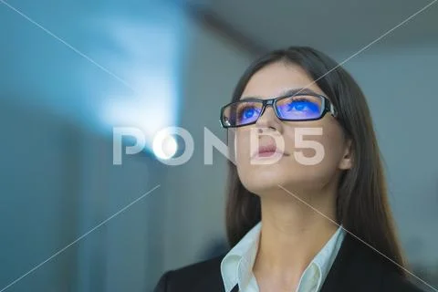 The businesswoman with glasses on the background of projector Stock Photos