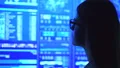 The businesswoman in glasses looking to the blue display 4k or 4k+ Resolution