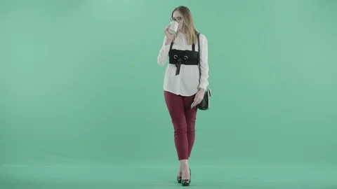 A businesswoman in glasses talks on the phone holding a mug in hand Stock Footage