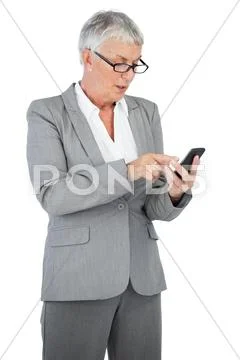 Businesswoman with glasses texting a message on her mobile phone Stock Photos