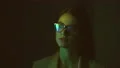 The businesswoman in glasses walking in a dark room near a display. slow motion 4k or 4k+ Resolution