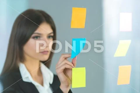 The businesswoman glues a sticker on the glass Stock Photos