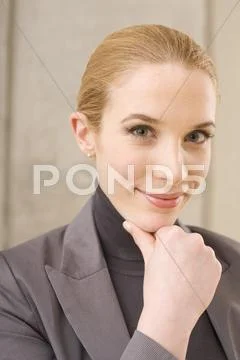 Businesswoman with hand to chin, portrait Stock Photos