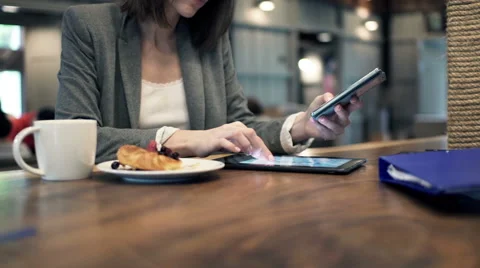 Businesswoman hands comparing data on tablet computer and smartphone in cafe HD Stock Footage 49705052