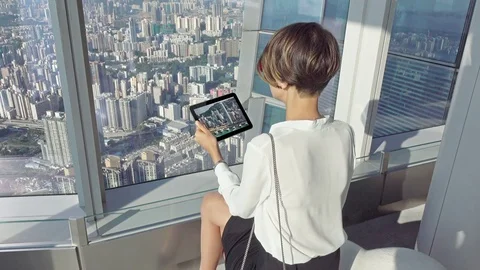 Businesswoman hands using tablet computer while sitting by desk in sky office Video stock 72662073