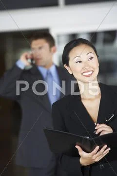 Businesswoman Holding Folder With Colleague On Call In Background Stock Photos