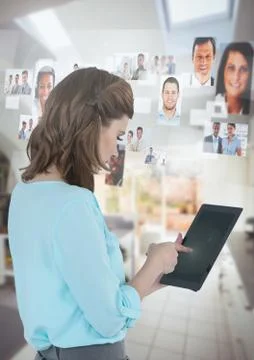 Businesswoman holding tablet with people's profile pictures at home Stock Photos