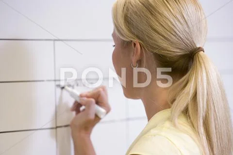 Businesswoman indoors writing on erasable board Stock Photos