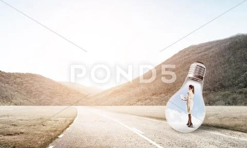 Businesswoman inside light bulb Stock Photos