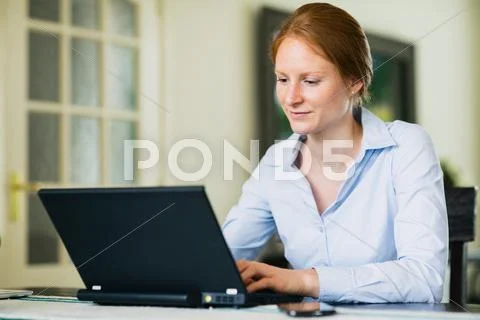 Businesswoman in a Living Room with Laptop Stock Photos