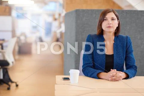 Businesswoman looking away while sitting at her office cubicle d Stock Photos