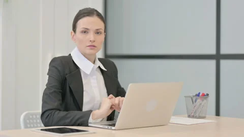 Businesswoman Looking at Camera while using Laptop 스톡 동영상 233378724