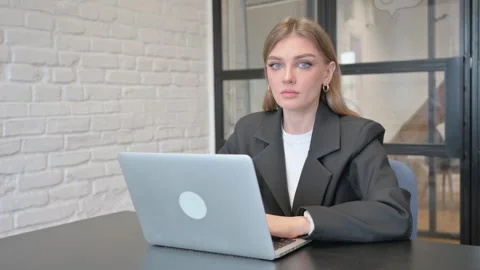 Businesswoman Looking at Camera while Working on Laptop in Office Stock Footage 301306039