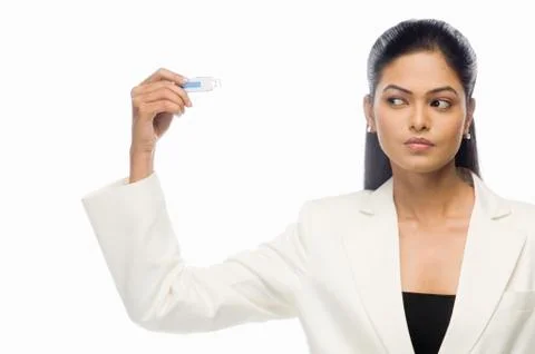 Businesswoman looking at a flash drive Stock Photos