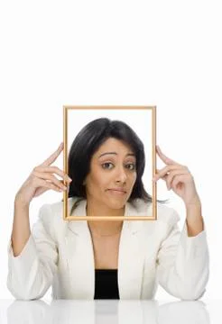 Businesswoman looking through a picture frame Stock Photos
