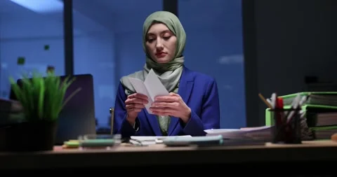 Businesswoman opens envelope in dark office removing document Stock Footage 317175553