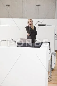 Businesswoman on phone at office cubicle Stock Photos