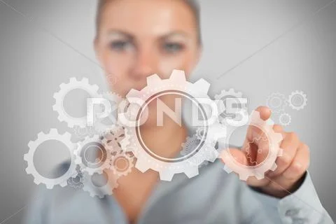 Businesswoman pressing wheels and cogs graphic Stock Photos