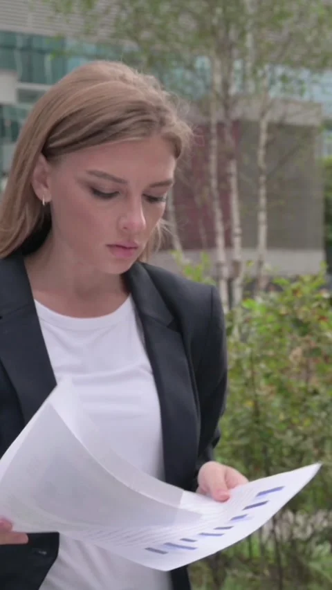 Businesswoman Reading Documents while Standing in Street, Vertical Video Stock Footage 340028735
