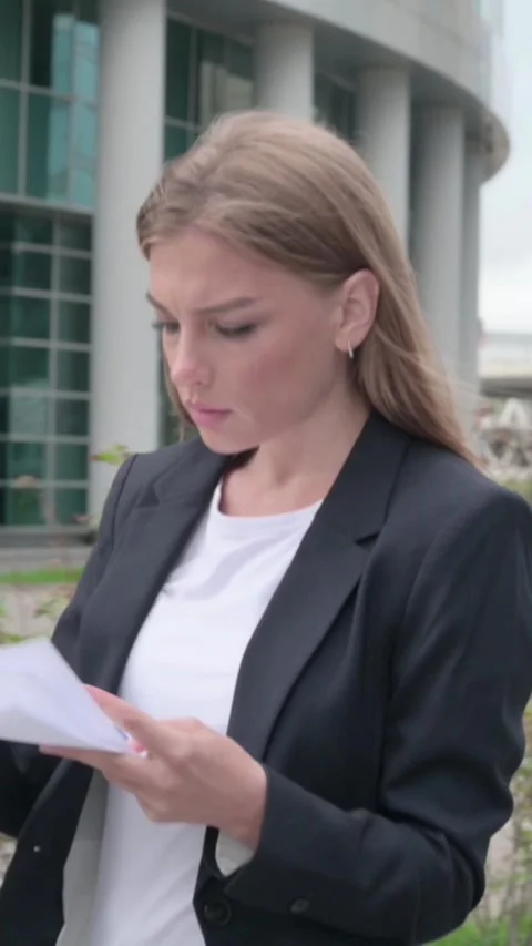 Businesswoman Reading Documents while Standing in Street, Vertical Video Stock Footage 340028814