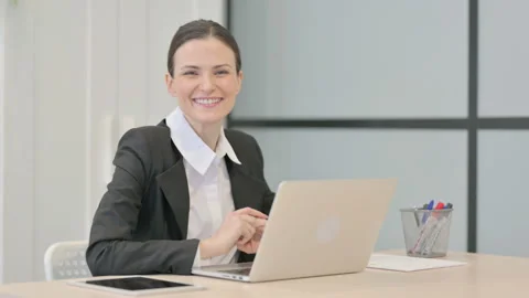 Businesswoman Smiling at Camera while using Laptop 스톡 동영상 233378738
