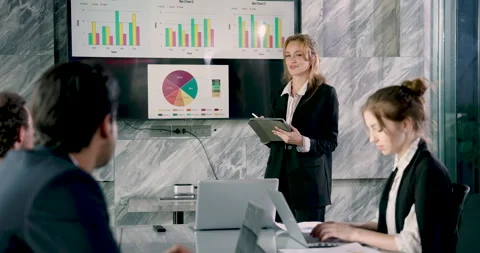 Businesswoman smiling while presenting visual report to diverse team during Stock Footage 336707509