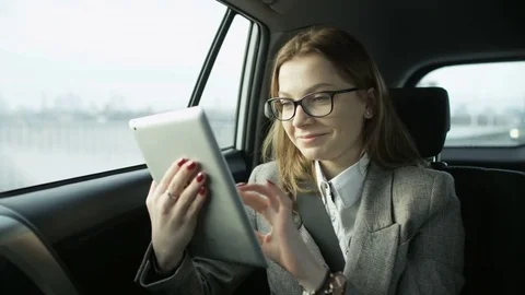 Businesswoman Smiling While Using a Tablet in the Car Stock Footage 84941761