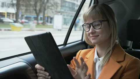 Businesswoman Smiling While Using a Tablet in the Car Stock Footage 87458096