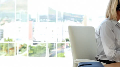 Businesswoman speaking on headset and typing Stock Footage
