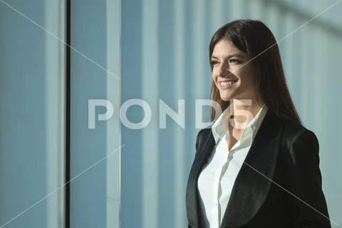 The businesswoman stand near the panoramic window Stock Photos