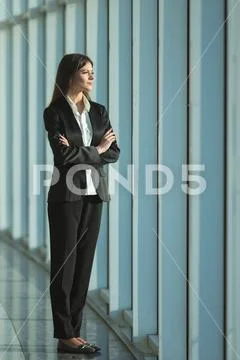 The businesswoman stand near the panoramic window Stock Photos