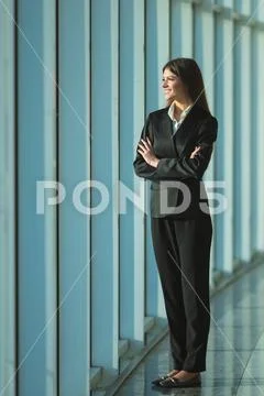 The businesswoman stand near the panoramic window Stock Photos
