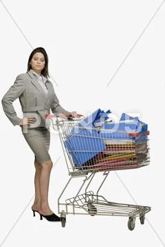 Businesswoman standing near a shopping cart filled with files Stock Photos
