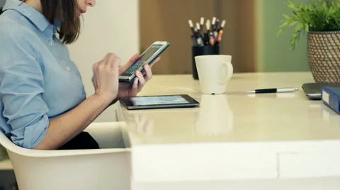 Businesswoman with tablet computer calculating data on smartphone by table HD Stock Footage 49729689