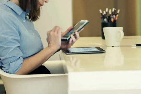 Businesswoman with tablet computer calculating data on smartphone by table  NTSC Stock Footage 49729705