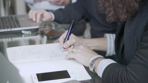 Businesswoman taking notes during a meeting. Stock Footage