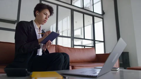 Businesswoman taking notes during remote lesson Stock Footage 334191519