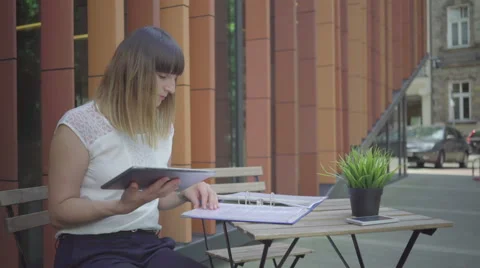 Businesswoman taking notes form folder to tablet, outdoor. Steadicam shot. Stock Footage 65332381