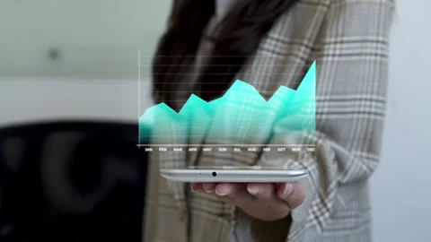Businesswoman taps tablet while projecting animated holographic chart showing Stock-Footage 345379939