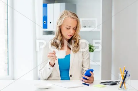Businesswoman texting on smartphone at office Stock Photos