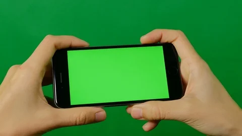 Businesswoman using a blank green screen mobile phone on green background. Stock Footage
