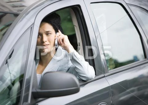 Businesswoman Using Cell Phone In Car