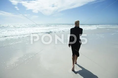 Businesswoman Using Cell Phone, Walking Barefoot Across Beach, Full Length, Rear