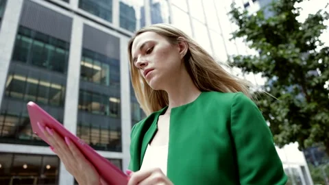 Businesswoman using digital tablet walking in financial district Stock Footage 346369002