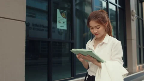 Businesswoman using digital tablet while walking alone outdoors in urban city. Stock Footage 149268011